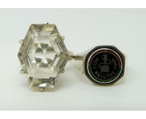 A silver ring set with a six sided mixed cut quartz and a silver ring set with enamel reading 'keep well the road'