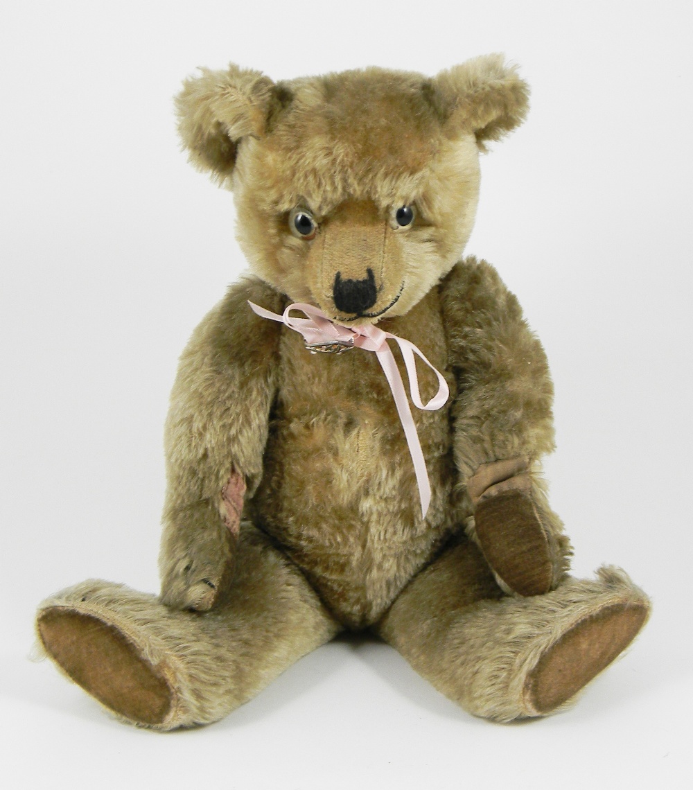 A Chiltern Hugmee Teddy Bear, circa 1930, the light brown mohair bear ...