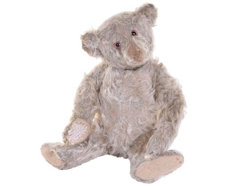 Steiff Teddy bear, German circa 1915, the straw filled light brown mohair bear with orange glass eyes, pointed muzzle and swi
