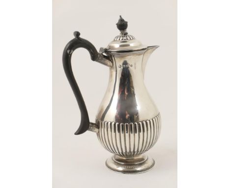 George V silver hot water jug, Sheffield 1929, half reeded pear shape with hinged cover, ebony finial and handle, height 25cm