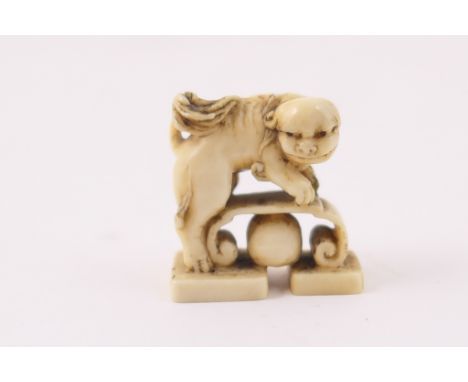 Japanese carved ivory netsuke, Meiji (1868-1912), carved as a shi-shi dog with bench and ball, height 3cm