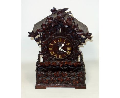 A Black Forest cuckoo table clock, late 19th century, possibly by Ketterer, lacking movement, the case carved with leaves and