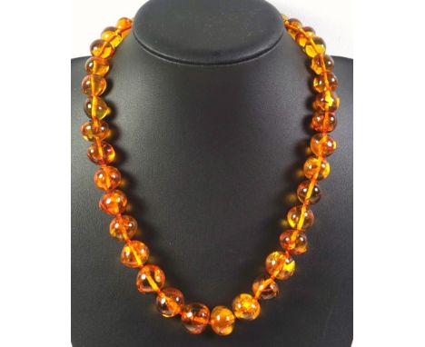 A vintage polished amber bead necklace 39 graduated beads with various inclusions, measuring 11mm - 20mm, length 57cm approx.