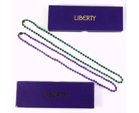 A green jade necklace with a white metal clasp stamped silver, length 69cm, the beads are 0.6cm in diameter approx., a purple