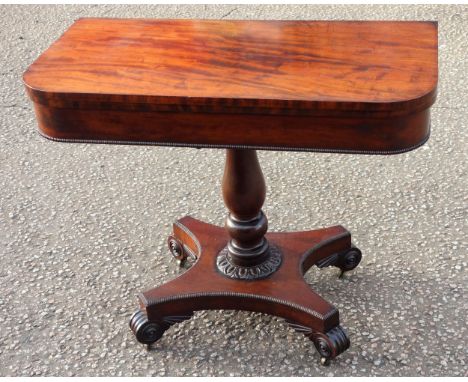 William IV mahogany folding rectangular card table with rounded corners, on a baluster column, hyperboloid base with 4 scroll