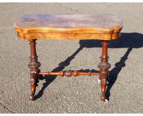 Fine Victorian figured walnut serpentine shaped card table with a folding revolving top, on 2 carved tapering cylindrical col