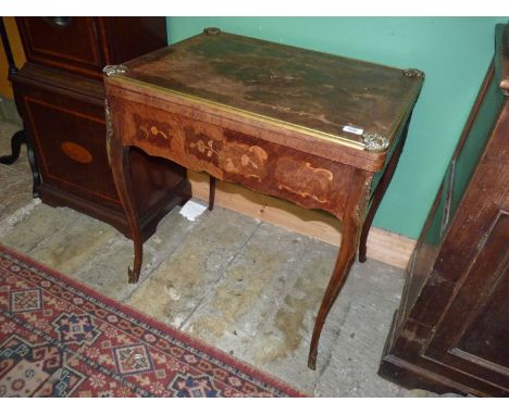 An inlaid mixed woods flapover Card Table of continental design and with brass and Ormolu fittings and mounts, standing on ca