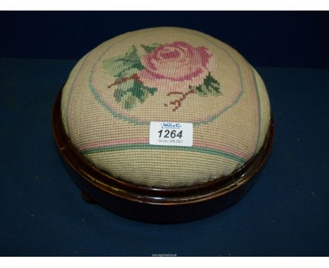 A tapestry topped circular footstool.