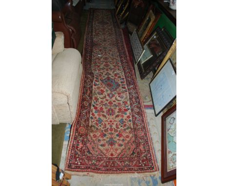 A Carpet Runner in cream and red floral pattern, 14'6'' long x 2'5'' wide.