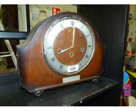 An Oak finished Mantle clock having chrome face, with key, 10" tall (commemorative plaque to front with details of 40 years s