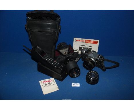 A Pentax AF 160 camera in case with two lenses and a Motorola 8900x-2 mobile phone and charger.