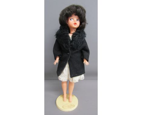 1960's Made in Hong Kong Sindy on a Pedigree Hong Kong stand - wearing original Sindy fur (faux) collared unlined black coat 