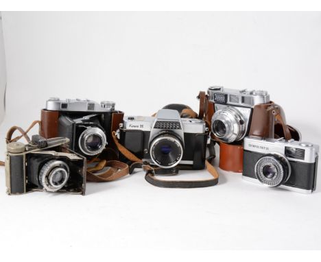 Collection of vintage SLR camers, including Olympus Trip 35, Kowa H SLR, others by Kodak, some in leather cases, along with a