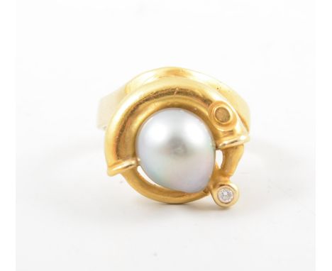 A baroque pearl dress ring, a 10mm grey baroque pearl peg set on an all yellow gold modern mount collet set with a small bril