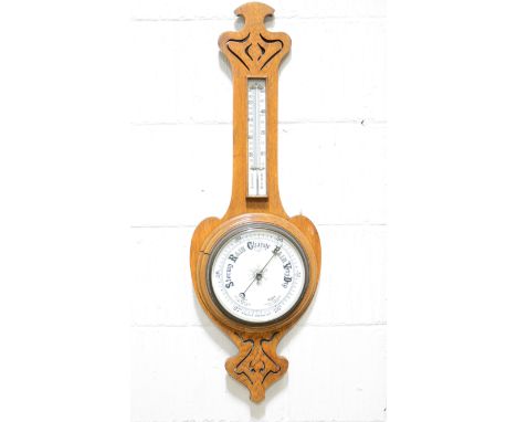 Edwardian oak wall mounted aneroid barometer, with thermometer, fretted frame, 88cm.