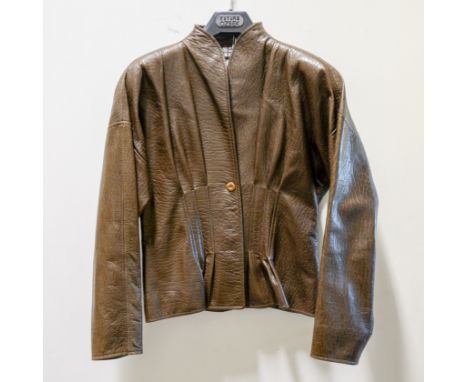 Jean Muir London - a brown leather jacket, pleated nipped in darted waist with centre back seam, no collar, four circular bro