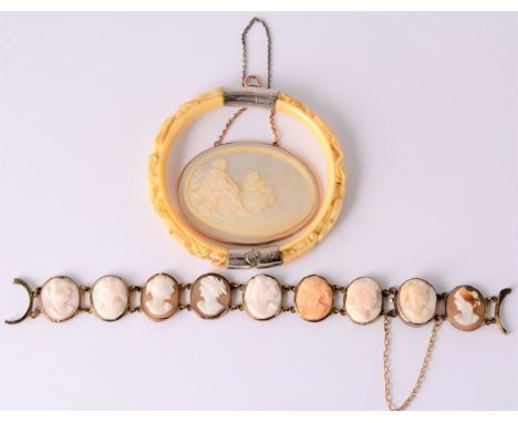 A carved mother-of-pearl pendant, the oval disc 46mm x 36mm shows a mother and child with dog looking out to sea in a plain r
