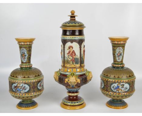 METTLACH; a pair of footed vases with cylindrical bodies and slender tapering necks, each decorated with four figural panels 