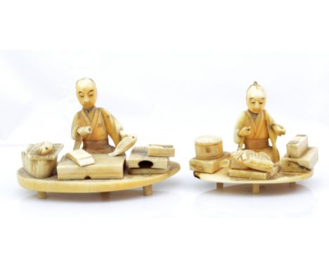 A Japanese Meiji period carved ivory figure of seated man descaling a fish at a board, on shaped oval base, raised on four pe