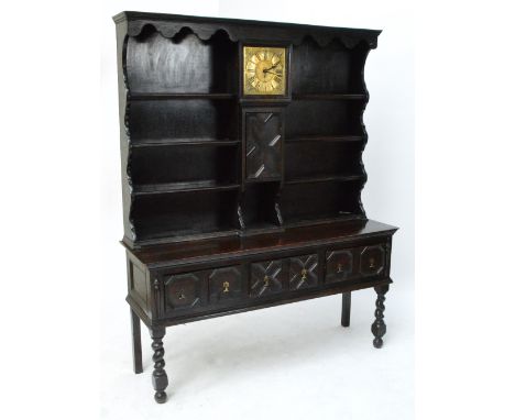 A 1920s oak dresser incorporating an 18th century brass 10" longcase clock dial, the chapter ring set with Roman numerals and