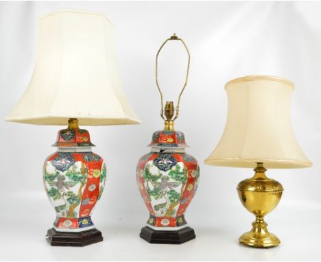 A pair of Oriental style ceramic table lamps mounted on hexagonal hardwood bases, height 67cm, with a brass table lamp, heigh