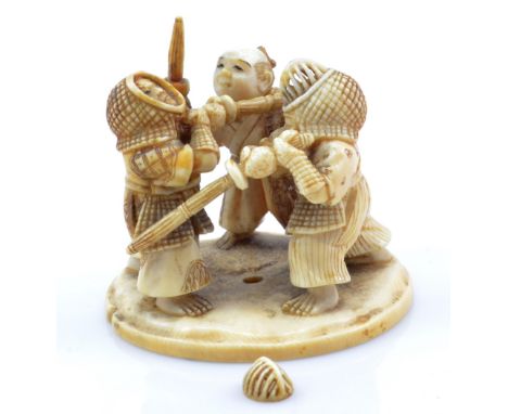 A Japanese Meiji period carved ivory figure group of two confronting kendo fighters with their master interfering, on shaped 