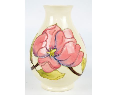 MOORCROFT; a "Magnolia" pattern tube line decorated baluster vase on cream ground, impressed marks and signature to base, can