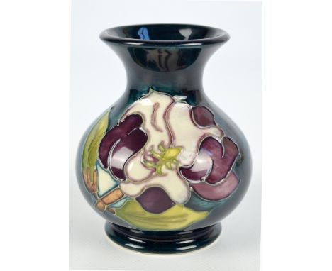 MOORCROFT; a modern "Magnolia" pattern tube line decorated baluster vase with flared rim on dark turquoise ground, impressed 