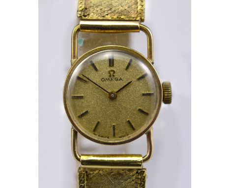 OMEGA; a 9ct yellow gold cased manual wind lady's wristwatch, the circular dial set with baton numerals, on textured gold bra