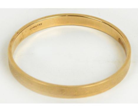 A 9ct yellow gold circular bangle with engine turned decoration to the outside, Birmingham 1921, diameter 7.5cm, 12.9g.