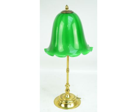 A brass table lamp with green glass domed shade and circular foot, height 61cm.