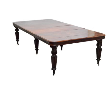 A 19th century mahogany six leg extending dining table, the rounded rectangular top raised on lobed fluted tapering legs to b