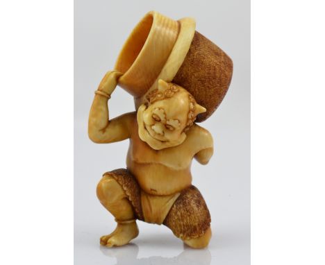 A Japanese Meiji period carved ivory netsuke of kneeling oni with pronounced spine and ribs, holding a basket on his back, sc