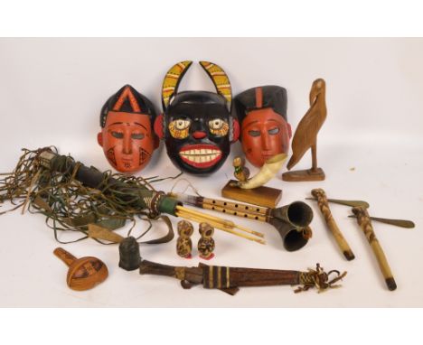 A collection of 20th century ethnic artifacts including masks, decorative quiver with arrows, knife in leather scabbard, scoo