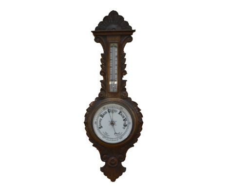 A late Victorian oak aneroid barometer/thermometer, carved with foliate motifs, height 87cm.
