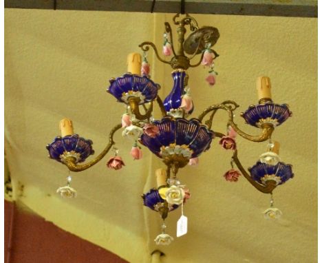 A French porcelain five branch electrolier with gilt heightened blue and white ceramic drip trays and support, with gilt meta