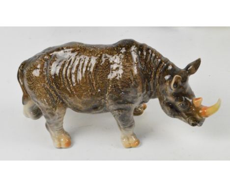 A ceramic figure of a rhinoceros, printed marks to base, length 32cm. 