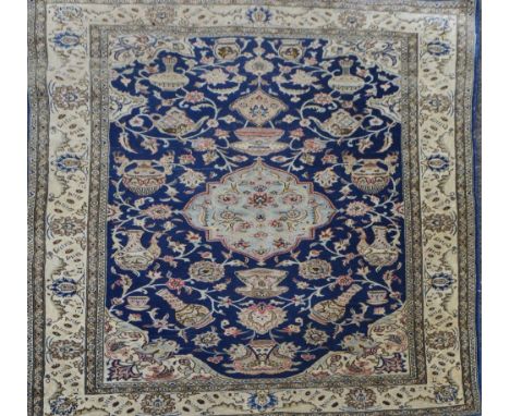 A Persian design rug with central main panel set with various ceramic objects including teapots and vases within a stylised f