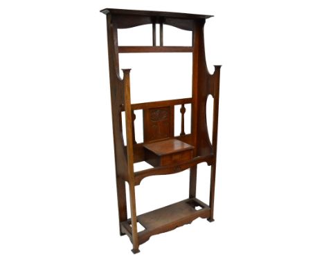 An Arts and Crafts oak hall stand with cornice top back panel carved with organic motif, shelf above drawer, flanked by umbre