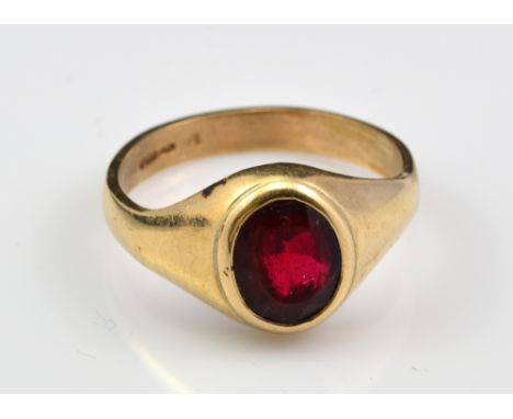 A 9ct yellow gold gentleman's signet ring with oval cut ruby coloured stone in bezel setting, size Z½, approx 8.6g.