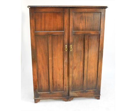 An early 20th century mahogany twin section gentleman's compactum, with twin panelled door enclosing fitted interior with var