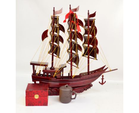 An Oriental hardwood model of a three masted schooner, the sails decorated with Oriental characters with a presentation inscr