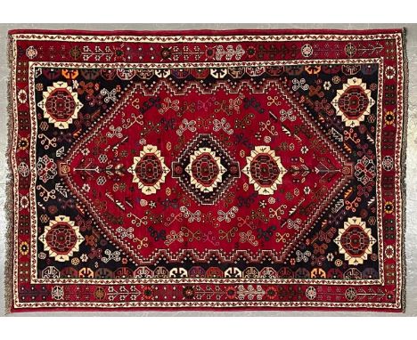 A 20th century South West Persian Islamic Qashgai floor carpet rug. The rug having a central a central red medallion with a s