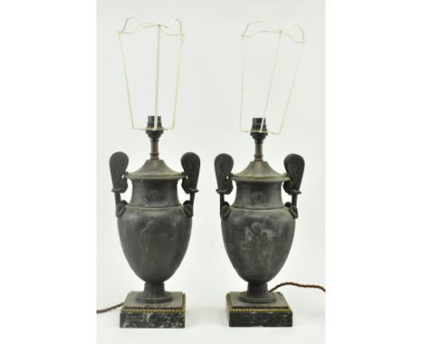 A pair of Neoclassical style metal amphora urn shaped desk table lamps. Each lamp having a flared neck flanked by scrolled tw