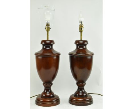 A pair of turned wooden desk table lamps shades in the shape of urn in the manner of Porta Romana. Each lamp having a flared 