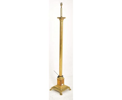 An early 20th century brass Neoclassical style floor standard lamp. The lamp having a Corinthian shaped capital over reeded c