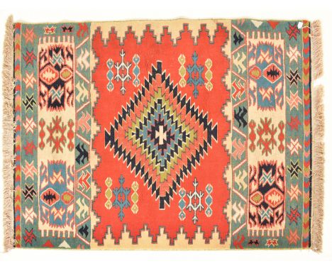 A 20th century Afghan Islamic Kilim floor carpet rug. The carpet having a central geometric diamond medallion within a red gr