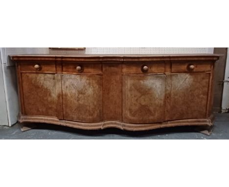 A large Continental early 20th century walnut serpentine front buffet sideboard credenza. The credenza having a shaped chamfe