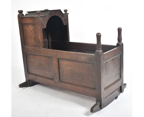 A 17th century country carved oak crib - bed. The crib with sleigh rockers and inset fielded panel to the sides and fronts. T