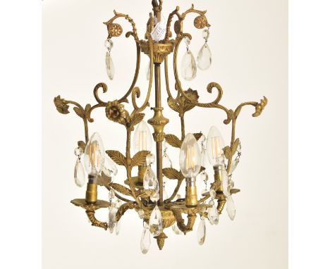 A French early 20th century ormolu &amp; faceted cut glass drops four-arm chandelier electrolier light. The light having scro